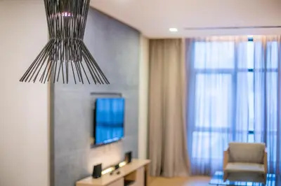 a living room with a chair and a chandelier at 188 Suites near KLCC with Parking and Bathtub in Kuala Lumpur