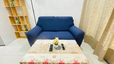 a blue couch with a table in a room at Summer Suites KLCC BY Lotus in Kuala Lumpur