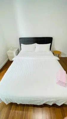 a large white bed with a black headboard at Summer Suites KLCC BY Lotus in Kuala Lumpur