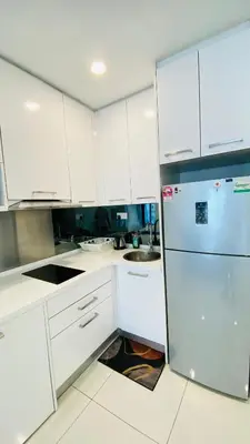 a kitchen with white cabinets and a refrigerator at Summer Suites KLCC BY Lotus in Kuala Lumpur