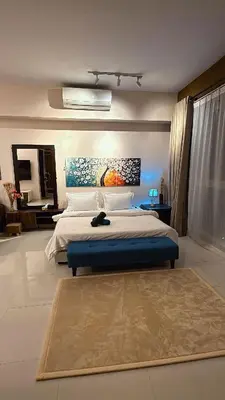 a bedroom with a large bed with a blue foot board at Infinity Sky Pool, Regalia Suite KLCC in Kuala Lumpur