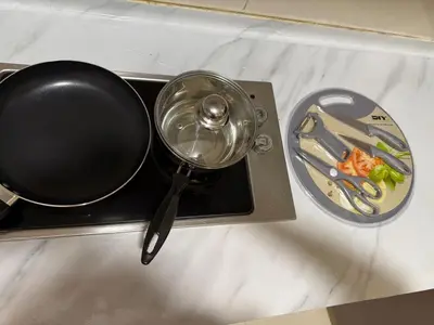 a frying pan on a stove with a plate of food at Infinity Sky Pool, Regalia KLCC in Kuala Lumpur