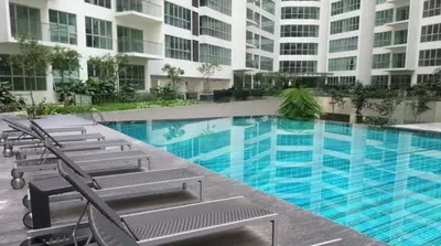 a swimming pool with lounge chairs in front of a building at Infinity Sky Pool, Regalia KLCC in Kuala Lumpur