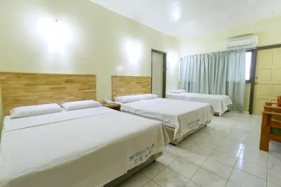 two beds in a hotel room with white sheets at Nan Yeang Hotel Petaling Street in Kuala Lumpur