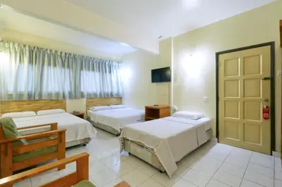 a hotel room with two beds and a television at Nan Yeang Hotel Petaling Street in Kuala Lumpur