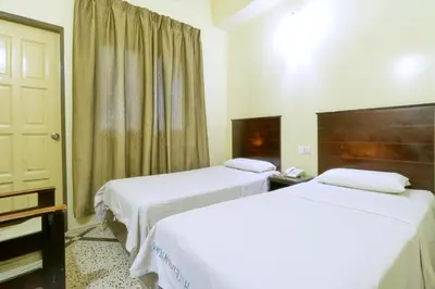 a hotel room with two beds and a window at Nan Yeang Hotel Petaling Street in Kuala Lumpur