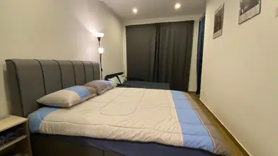 a bedroom with a large bed with blue and white pillows at Setapak Central Mall in Kuala Lumpur