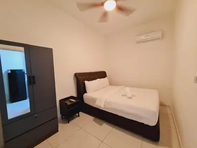 a small bedroom with a bed and a ceiling fan at Majestic Residence KLCC By AMG in Kuala Lumpur
