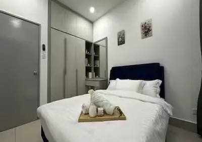 a white bed with a tray with a cat on it at K&L Suites Razak City Kuala Lumpur in Kuala Lumpur