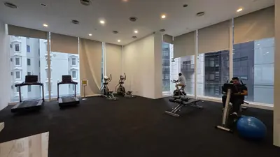 a gym with people exercising on machines in a building at KLCC Binjai 8 Premium Soho Apartment by prime suites in Kuala Lumpur