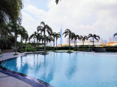 a large swimming pool with palm trees in a city at Trion Residence Kuala Lumpur by Centrix in Kuala Lumpur