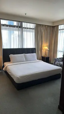 a large bed in a bedroom with a large window at KL City Tour Residence Berjaya Times Square in Kuala Lumpur