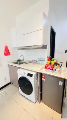 a kitchen with a washing machine and a sink at Butterfly Home in Kuala Lumpur