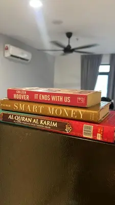 a stack of books sitting on top of a shelf at Butterfly Home in Kuala Lumpur