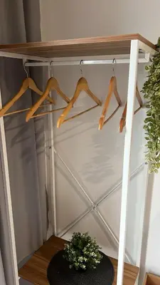 a closet with wooden hangers and a plant on a table at Butterfly Home in Kuala Lumpur
