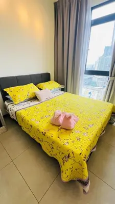 a bedroom with a yellow bed with yellow sheets and a window at Butterfly Home in Kuala Lumpur