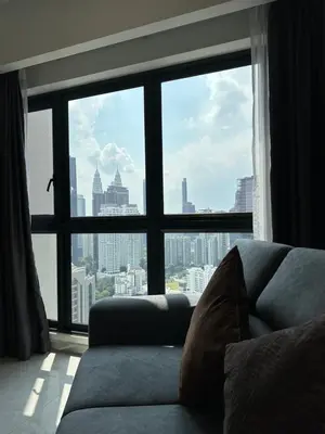 a couch sitting in front of a large window at Sky Line Agile Suites KL in Kuala Lumpur