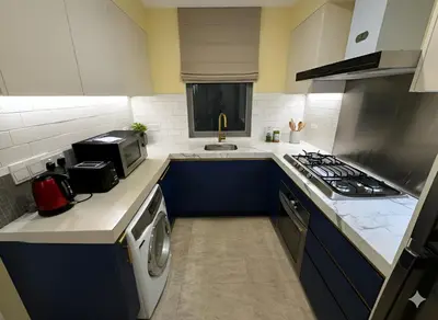 a kitchen with blue cabinets and a stove top oven at Luxury Fairlane Residence Suites Kuala Lumpur by AZI BNB in Kuala Lumpur