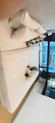 a bed with white sheets and pillows on it at The platinum KLCC by suites hospitality in Kuala Lumpur
