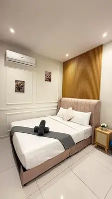 a bedroom with a bed with a black hat on it at Majestic Residence Suites KLCC in Kuala Lumpur