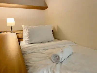 a bed with white sheets and a pillow and a lamp at 1-5 people, Scandinavian Style Arcoris Mont Kiara in Kuala Lumpur