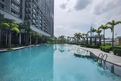 a large swimming pool with palm trees and buildings at Trion Hotel by HAVENZA near TRX, Time Square and Bukit Bintang in Kuala Lumpur