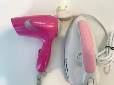 a pink and white hair dryer next to a hairdryer at Max 5pax, Muji Style Apartment Arcoris Mont Kiara in Kuala Lumpur