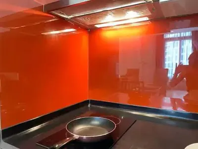 a kitchen with an orange wall and a pot on a stove at Max 5pax, Muji Style Apartment Arcoris Mont Kiara in Kuala Lumpur