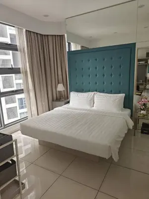 a bedroom with a large bed with a blue headboard at Martin House KL in Kuala Lumpur