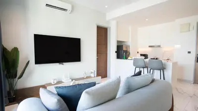 a living room with a couch and a tv on a wall at Alfa Bangsar by Guestonic in Kuala Lumpur