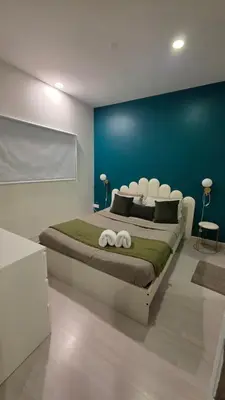 a bedroom with a large bed with a blue wall at Binjai 8 KLCC Premium Soho By Prime Suites in Kuala Lumpur