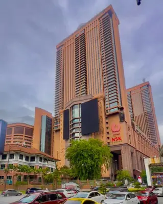 a tall building with cars parked in a parking lot at Elegant Apartment at Times Square in Kuala Lumpur