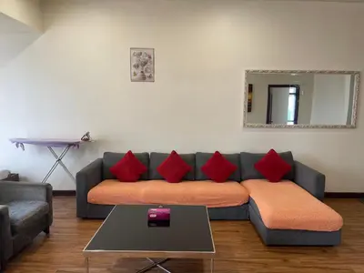 a living room with a couch with red pillows at Elegant Apartment at Times Square in Kuala Lumpur