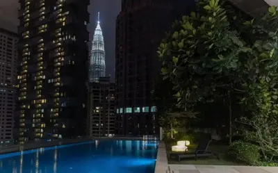 a view of a city skyline at night with a swimming pool at Bodhi Banyan Pavilion Kuala Lumpur by WSD in Kuala Lumpur