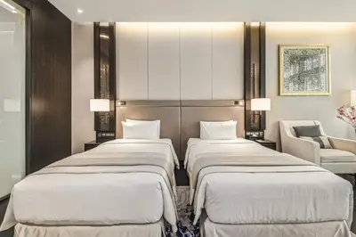 a hotel room with three beds and a chair at Bodhi Banyan Pavilion Kuala Lumpur by WSD in Kuala Lumpur