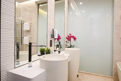 a white bathroom with a sink and a mirror at Bodhi Banyan Pavilion Kuala Lumpur by WSD in Kuala Lumpur