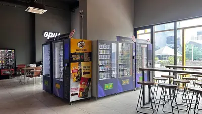 a store with a drink vending machines and tables and chairs at Opus Kuala Lumpur by WSD in Kuala Lumpur