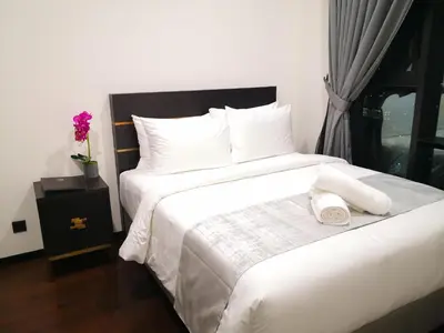 a bedroom with a bed with white sheets and pillows at Opus Kuala Lumpur by WSD in Kuala Lumpur