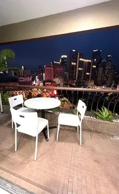 a table and chairs on a roof with a city skyline at Apartment in bukit bintang in Kuala Lumpur