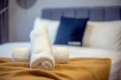a taped up leg on top of a bed at Astoria Ampang Modern 2Bedroom Suite Free Parking in Kuala Lumpur