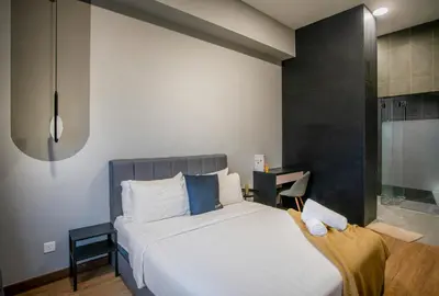 a bedroom with a large white bed with blue pillows at Astoria Ampang Modern 2Bedroom Suite Free Parking in Kuala Lumpur
