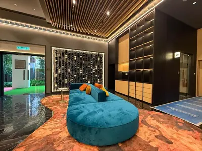 a large blue couch in a room with a wine cellar at Royale Suites At Majestic Residence KL in Kuala Lumpur