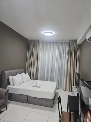 a bedroom with a bed and a couch and a television at Royale Suites At Majestic Residence KL in Kuala Lumpur