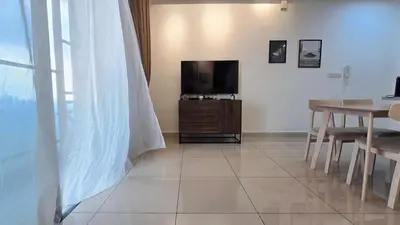 a living room with a television and a dining room table at Trion KL Star Suites in Kuala Lumpur