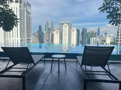 two chairs and a table on a balcony with a city skyline at Luxury suite for couple 267A at KLCC in Kuala Lumpur