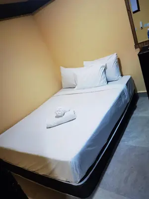 a large white bed with a towel on it at Moonlight Inn Bukit Bintang in Kuala Lumpur