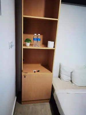 a cabinet with bottles of water and a bed at Moonlight Inn Bukit Bintang in Kuala Lumpur