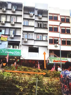 a tall building with flags in front of it at Moonlight Inn Bukit Bintang in Kuala Lumpur