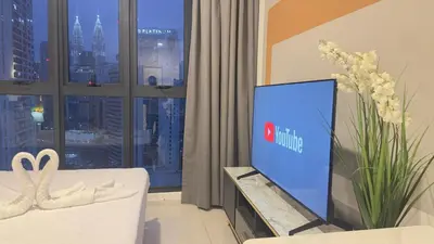 a living room with a tv and a white couch at Luxury suite 293A at KLCC in Kuala Lumpur