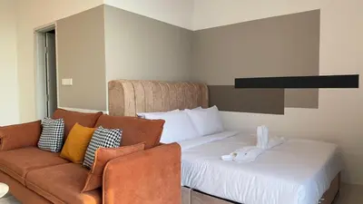 a hotel room with a bed and a couch at Private family apartment 27131BR at Majestic Residence in Kuala Lumpur